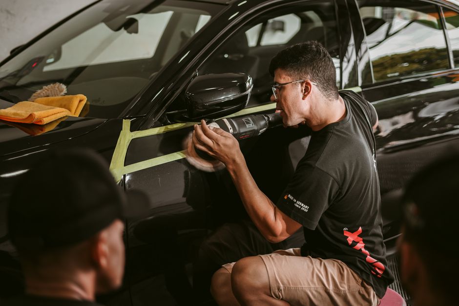 Professional detailer polishing a car to perfection